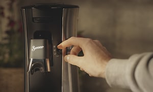 Närbild på en hand som justerar kaffeintensiteten på en Senseo Select kaffemaskin