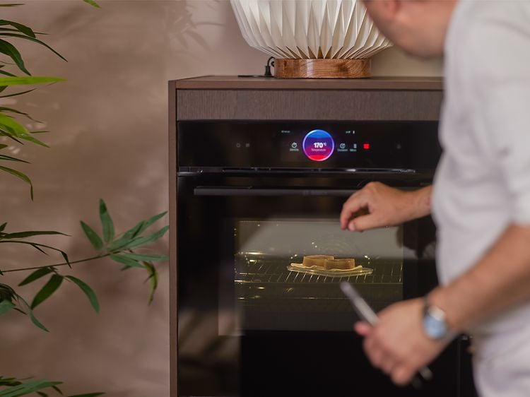 Chef steaming fish in plastic box in a Bosch accent line oven with steam function