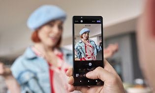 Sony Xperia 5 V används för att ta ett foto av en poserande kvinna