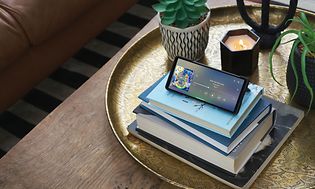 Sony Xperia 5 V placerad ovanpå en hög med böcker