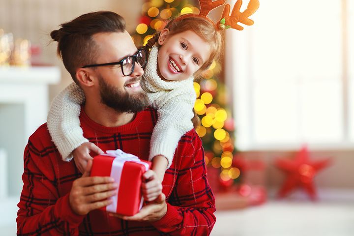 Ett barn ger en julklapp till sin pappa