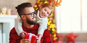 Ett barn ger en julklapp till sin pappa