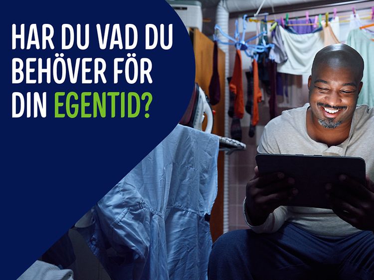 Man has escaped to a laundry room with his tablet. Banner text: Har du vad du behöver för din egentid?