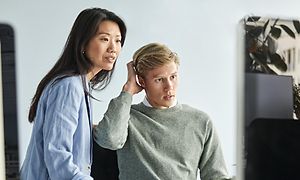  Man och kvinna tittar på en datorskärm på kontoret
