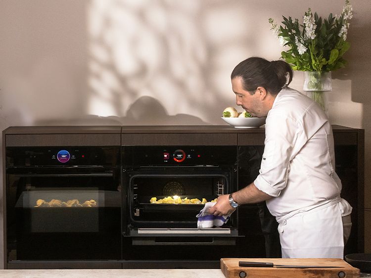 Chef taking out the cauliflower of a Bosch accent line oven with airfryer
