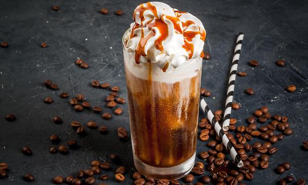 Ett högt glas med Frappuccino toppad med vispgrädde