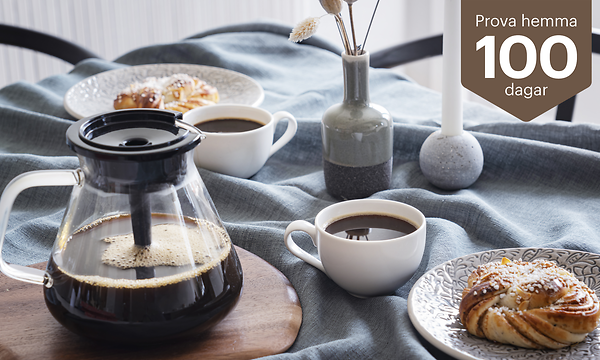Blooming kaffebryggare på ett bord bredvid kaffekoppar och bakverk