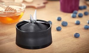 Bosch VitaPower mixermotor med blad på ett bord bredvid blåbär och honung