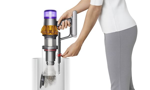 Person som tömmer en skaftdammsugare från Dyson