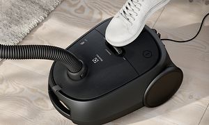 Electrolux Clean 600 Bagged vacuum cleaner in black and a human foot using the foot control