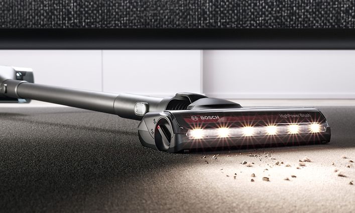 Cordless Bosch vacuum cleaning crumbs under the sofa