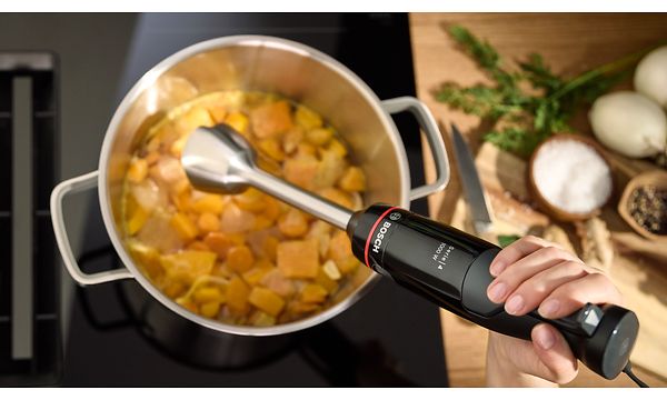 Bosch - SDA - Person using Bosch MSM4B623 ErgoMaster hand blender on food in a kettle