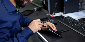 Servicemedarbetare fixar en smartphone