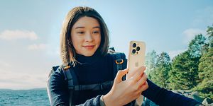 Woman with backpack holding an iPhone 16 Pro