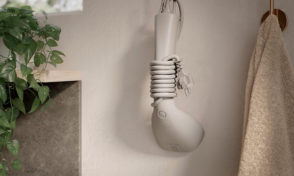 The steamer Electrolux Refine 700 hanging neatly on a wall