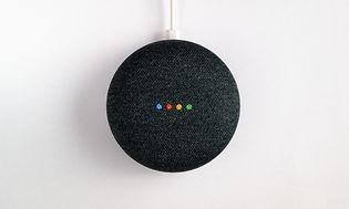 En Google Home Mini eller Home Nest mot vit bakgrund