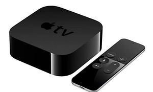 En Apple TV dosa i svart med tillhörande fjärrkontroll, vit bakgrund. 
