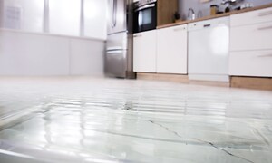 Ett ljust kök med massa vatten på golvet.  