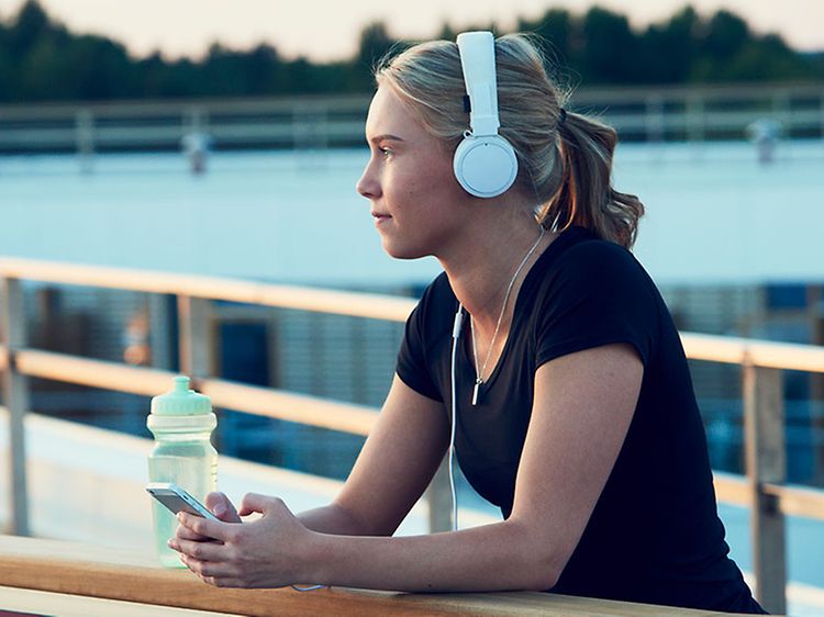 Kvinna som lyssnar på podcast när hon tränar