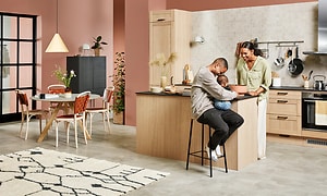 En familj är samlad i ett modernt Epoq-kök i livliga färger.