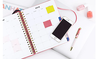 En bunt papper, en uppslagen kalender och en mobiltelefon i en hög . Bredvis ligger en penna och några flaskor nagellack.