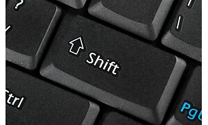 Närbild på shift-knappen på ett svart tangentbord. 