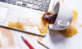 Olycka - kaffe som spillts över en bärbar dator.
