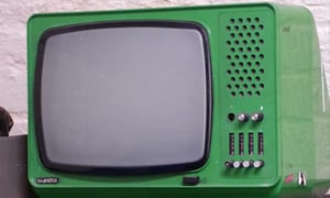 Närbild på en liten retro tjock-TV i grön färg. 