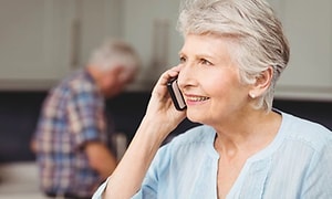 En äldre kvinna som talar i sin mobiltelefonen.