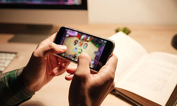 Närbild: Person som spelar spel på mobiltelefon.