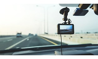 En bilkamera med display fäst på framrutan i bilen och filmar vägen framför.  