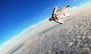 Man i en vit så kallad wingsuit, flyger ovan molnen.