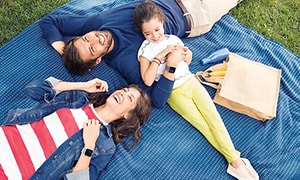 En familj chillar på en piknikfilt.