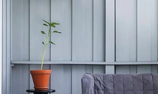 Wall-mounted terrace heater over a green plant and a couch