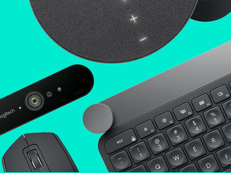 Datortillbehör från Logitech, webbkamera, mus, tangentbord och musmatta i svart på grön bakgrund.