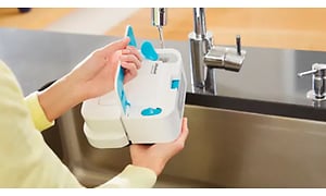 woman filling her mopping robot with water