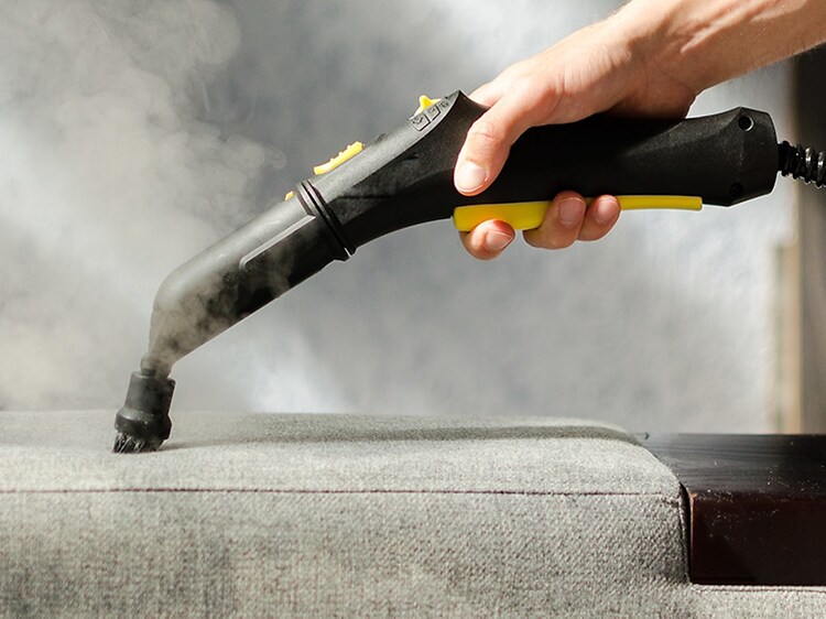 Ångtvätt som används på en soffa med ett textilmunstycke.