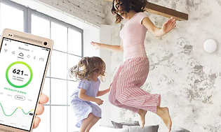 Kvinna och barn som hoppar och Airthings -appen på telefonen