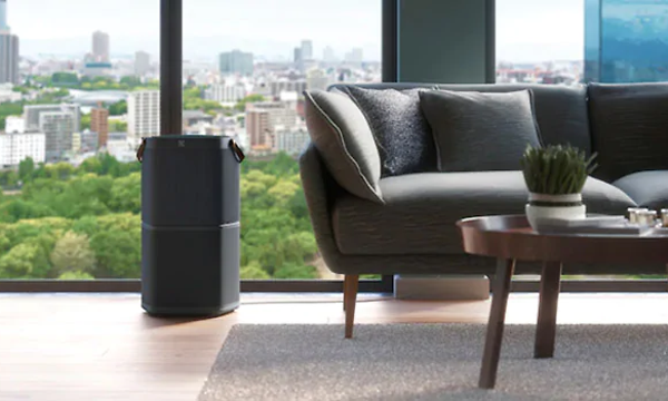 Electrolux luftrenare i ett vardagsrum med modern stil och stora fönster med stadsvy utanför. 